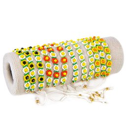 A set of 12 pearl bracelets with a colorful floral pattern. The bracelets feature a mix of yellow, orange, and red flowers arranged in a repeating design. The bracelets have an adjustable cord closure for a comfortable fit.