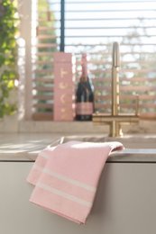 A soft, absorbent herringbone-patterned kitchen towel available in turquoise, yellow, and pink colors. The towel features a classic design that is both functional and stylish for any kitchen.