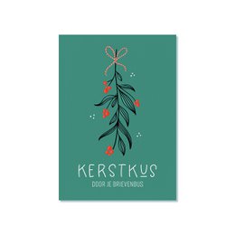 A Christmas card with a festive design featuring a branch with leaves and berries. The text on the card reads "Kerstkus door je brievenbus" which means "Christmas kiss through your mailbox" in Dutch.