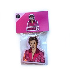 A pink and red keychain featuring a stylized image of a person with dark hair wearing a pink shirt.