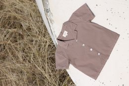 Taupe baby shirt with short sleeves and button-up closure.