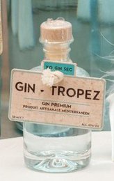 Gin Tropez 0.5L, a clear, light blue-green colored gin with a botanical garnish in a glass.