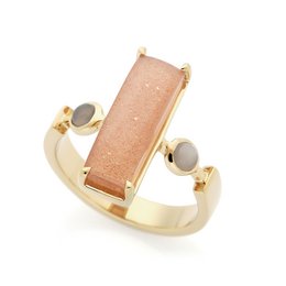 Rectangular peach-colored stone set in a gold-tone ring with round accents. Stylish statement ring.