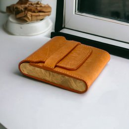  A rectangular cigarette case made of cowhide leather and walnut wood, available in orange, black, dark brown, and light brown colors.