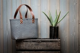 Stylish black and white checkered shopping bag made from recycled materials, with leather handles and trim. Ideal for everyday use, beach trips, or as a reusable grocery tote.