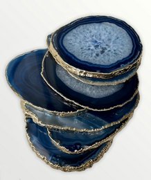 Blue agate coasters with natural stone patterns and gold trim.