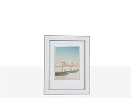 A white photo frame with a beach scene depicting two flamingos standing in shallow water.