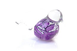 Decorative statue of a purple bird with white stripes. The statue has a unique cracked and textured surface, giving it an artistic and abstract appearance.