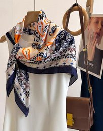  A square scarf made of polyester with a silk effect, featuring vintage chic floral patterns in maroon, black, and blue colors.