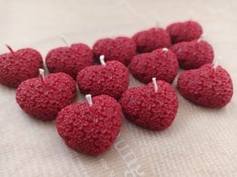 Heart-shaped red beeswax tealight candles, ideal for romantic occasions.