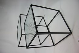 A set of two modern, minimalist optical glass side tables with a sleek, geometric black metal frame design. The tables feature a transparent glass top and a simple, clean aesthetic suitable for a contemporary living room or office space.