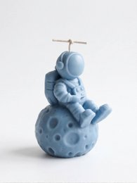  Blue astronaut candle sitting on moon, space-themed decorative dinner candle with celestial design.