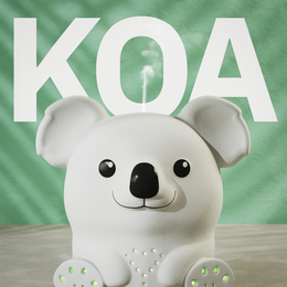  A white koala-shaped essential oil diffuser with the word "KOA" prominently displayed. The diffuser has a mint green packaging with a simple design.