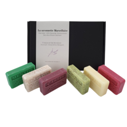 A set of 6 traditional Marseille soap bars in various scents, including cassis, pastis, red vine, mint, coconut milk, and mojito. The bars are handmade and packaged in a gift box.