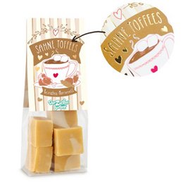 Cream-colored toffee candies in a clear plastic bag with a label that says "Salted Toffees". The toffees appear to be square or rectangular in shape and have a golden, caramelized color.