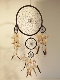 A classic black dream catcher measuring 25 cm, featuring a traditional woven design with feathers and beads.