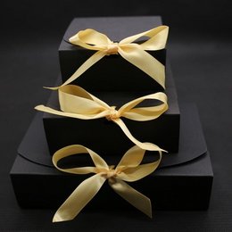 Gift boxes in various colors and sizes, including brown, deep blue, red, white, and black. The boxes are wrapped with decorative ribbons in a contrasting color.