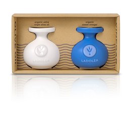 Two glass bottles containing organic extra virgin olive oil and organic balsamic vinegar, packaged in a cardboard box.