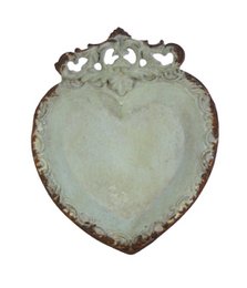 A decorative heart-shaped dish in a light green color with an ornate, vintage-inspired design.