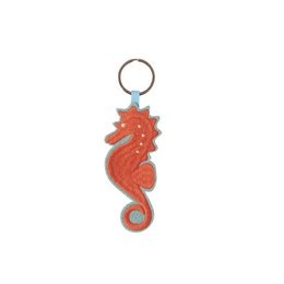 Keyring in the shape of a red seahorse with a metal ring for attaching to keys or bags. Made of durable, textured material.