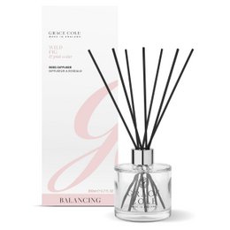  A tall, cylindrical glass diffuser bottle filled with a clear liquid and containing black reed sticks. The bottle has a white label with pink and black accents, indicating the product is a "Wild Fig and Pink Cedar Diffuser 200ml" from the "Balancing" collection.