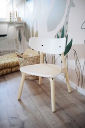 A small, white wooden chair with a simple, minimalist design. It appears to be a children's or kid's chair, suitable for use in a nursery or playroom.