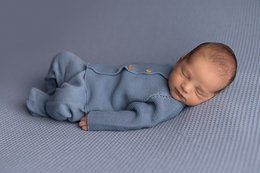 Newborn pack links jeans, a soft blue knitted onesie for babies 0-6 months, featuring a button-up front closure.