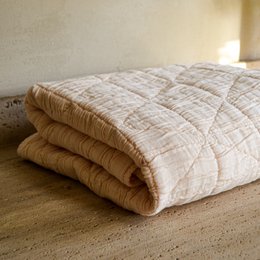  Soft, cozy cream-colored baby blanket with a quilted pattern, available in two sizes: 80 x 100 cm and 90 x 125 cm.