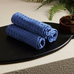 Cobalt blue cotton waffle weave face towel, soft textured rolled hand towel for bathroom.