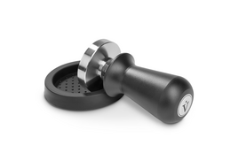 Tamper set with pressure-regulating contact pressure of approximately 14kg through an integrated spring, available in 51mm and 58mm sizes with black or wooden handles, for use with coffee machines.