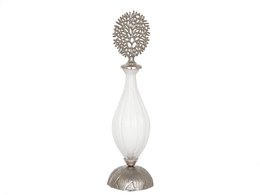 Silver glass bottle with golden metal lid. Tall, round shape. Decorative floral design on lid.