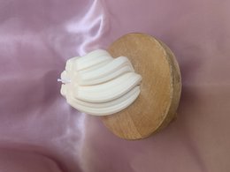 Tall, cylindrical white candle with a swirling, textured design on a wooden base.