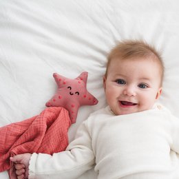  Organic cotton whale doudou, a soft and cuddly comfort blanket for babies. Features a star-shaped plush toy in a warm coral color, made from high-quality natural materials.