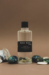 A clear glass bottle with a black label containing a hydrosol product made from white fir and labradorite crystals. The product is part of the cleansers category and available in 50ml and 100ml sizes.