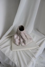 Glossy, handmade vase with a unique, organic shape and textured surface.