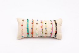  16 pieces of assorted woven bracelets on a roll. Includes a variety of colors, materials, and styles such as beaded, braided, and knotted designs.