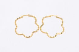 Gold-tone stainless steel hoop earrings with a floral design.