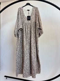 "Flowy maxi dress with leopard print pattern, three-quarter length sleeves, neutral beige and black tones, relaxed silhouette."
