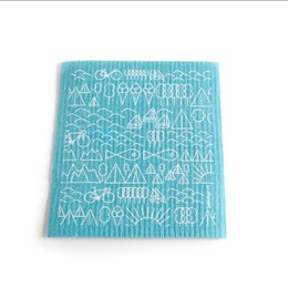 A blue and white patterned Swedish dish cloth with a travel-inspired design, suitable for cleaning and drying dishes.