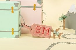 Pink luggage tag with stitched design, suitable for smartphone cases.