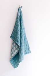 Teal blue and white patterned tea towel made of cotton.