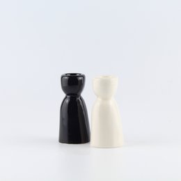 Ceramic candle holder in black and cream colors, with a simple, minimalist design.