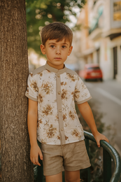 White short-sleeved kids' dress shirt with a floral print pattern featuring brown and yellow flowers.