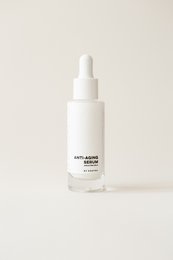 Anti-aging serum in a white bottle with a dropper. Lightweight, hydrating formula to reduce the appearance of fine lines and wrinkles.
