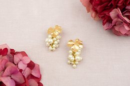 Elegant gold-toned statement earrings with clusters of pearls and crystals. Suitable for formal or special occasions.