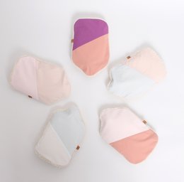 Soft, cozy hot water bottle made from recycled materials in a modern geometric design. Available in pink and purple color blocks.