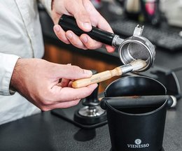 A cleaning brush for coffee grinders, portafilters, and espresso machines. Available in light brown and brown colors. The brush has a wooden handle and natural bristles to effectively clean coffee equipment.