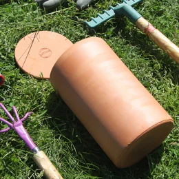 Terracotta planter tube for burying in the ground, available in 3L, 6L, 1L, and 2L sizes. Made of durable, natural materials suitable for outdoor use.