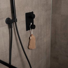 Solid brown bar soap in a woven natural fiber container. The soap bar has a simple, minimalist design and the container adds a rustic, textured element.