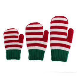  Knitted Christmas mittens in a festive red and white striped pattern with green cuffs, perfect for keeping little hands warm during the holiday season.